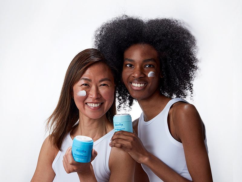 Two models holding Skinfix products