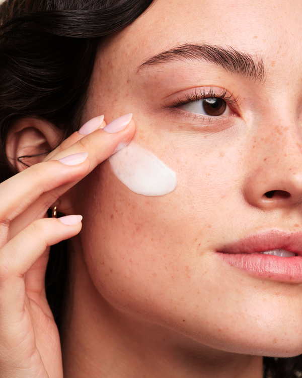 Close-up of a person applying cream to their face