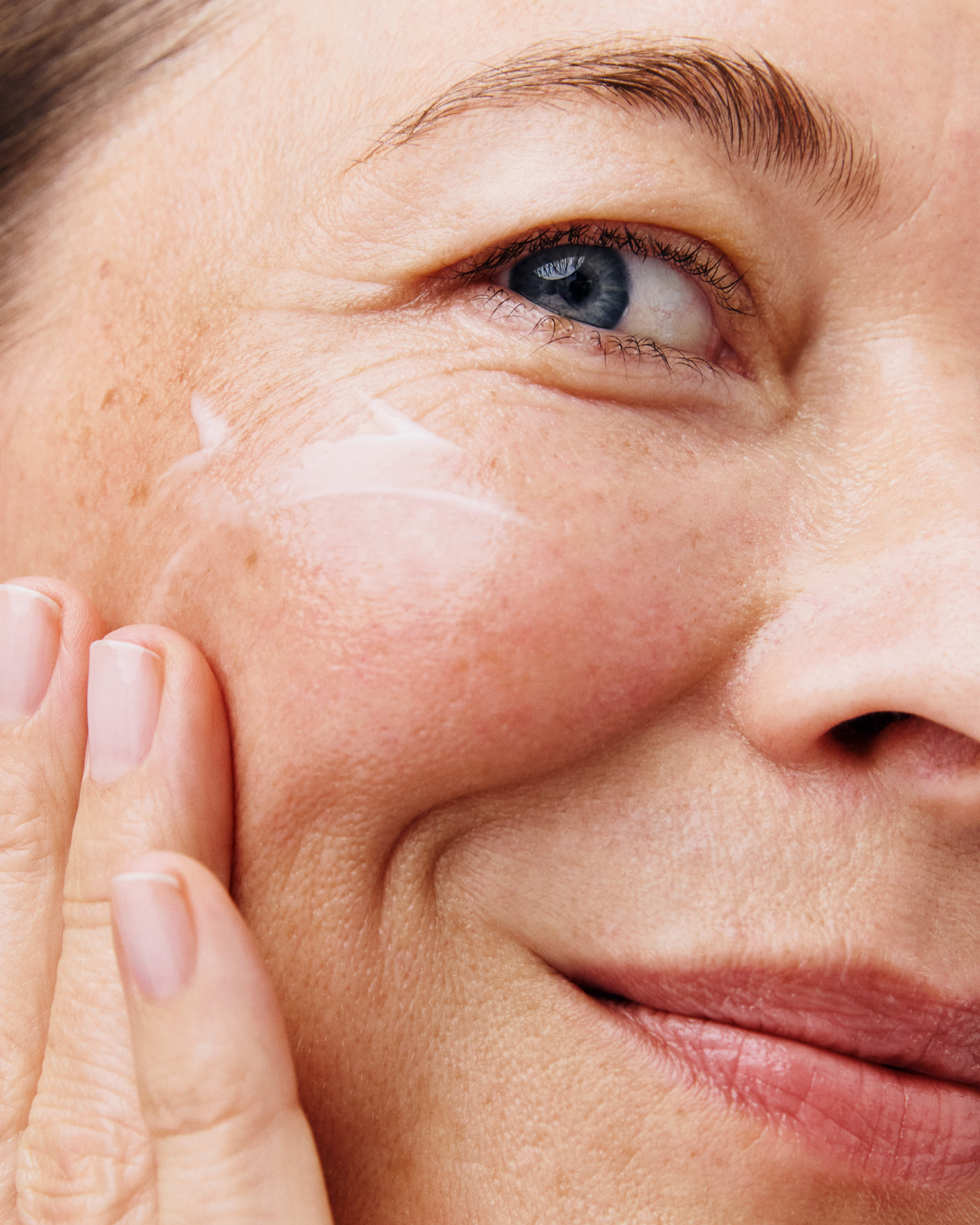 Person applying Skinfix Triple Lipid Activating Serum to their cheek.