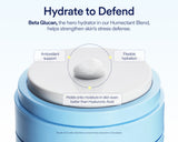 A blue cosmetic jar with a white lid on a light blue background, featuring marketing text about Beta Glucan and callout labels pointing to antioxidant support, flexible hydration, and moisture holding.