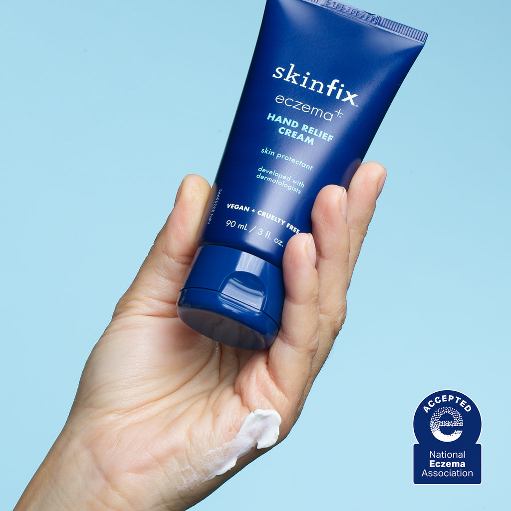 Image of hand holding blue bottle Skinfix Hand Relief Cream with texture swatch on hand. Also shown is National Eczema Association Seal of Acceptance.