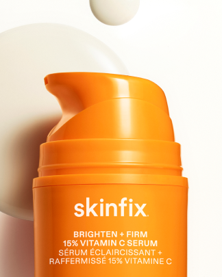 Skinfix Brighten + Firm 15% Vitamin C Serum bottle with product texture in the background.